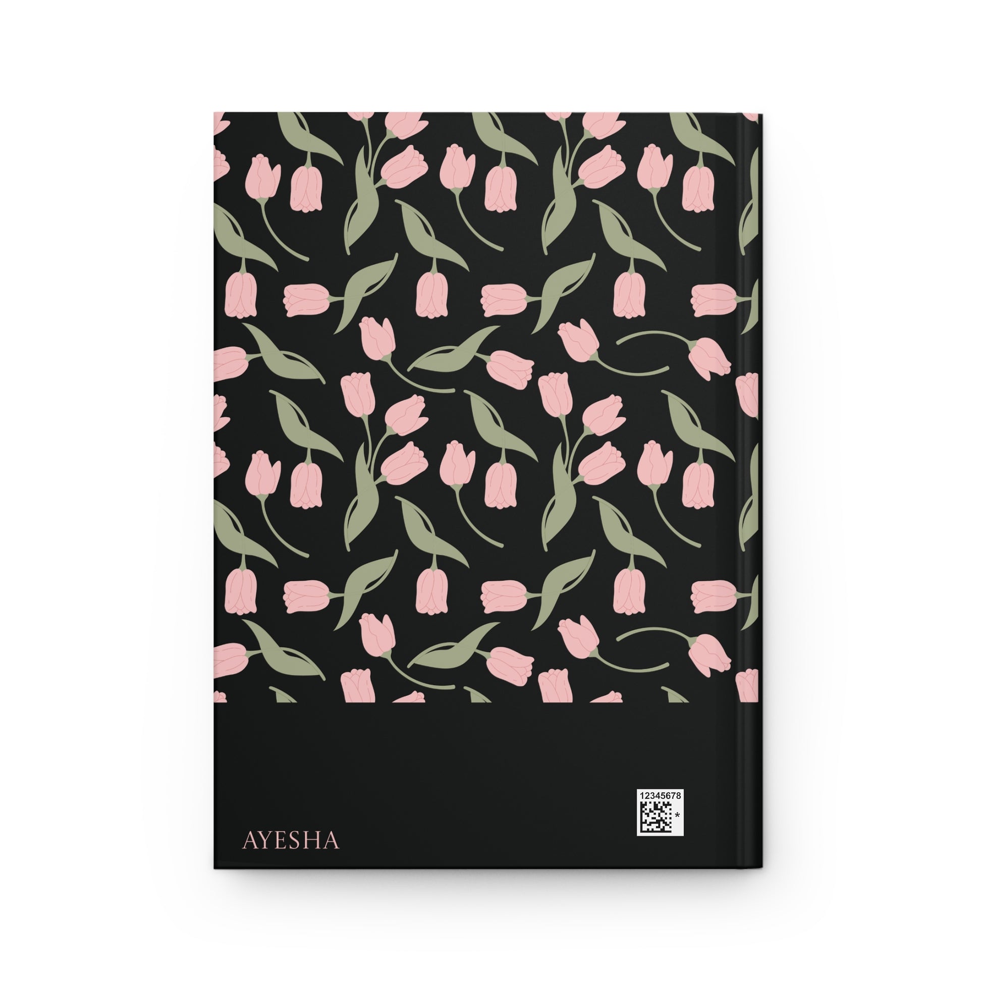 Back cover of a black Qur'an journal with a personalizable name "AYESHA".  The back cover features soft pink floral and leaf artwork.