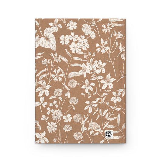 Back cover of a Quran notebook with white floral art on a brown background.